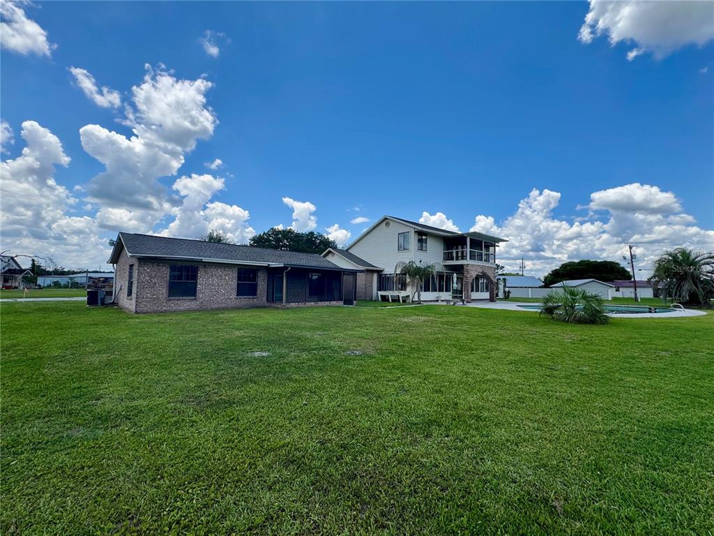 A two-story house with a brick wing, a pool, and a large grassy yard — 14371 US HIGHWAY 301 S, STARKE, FL