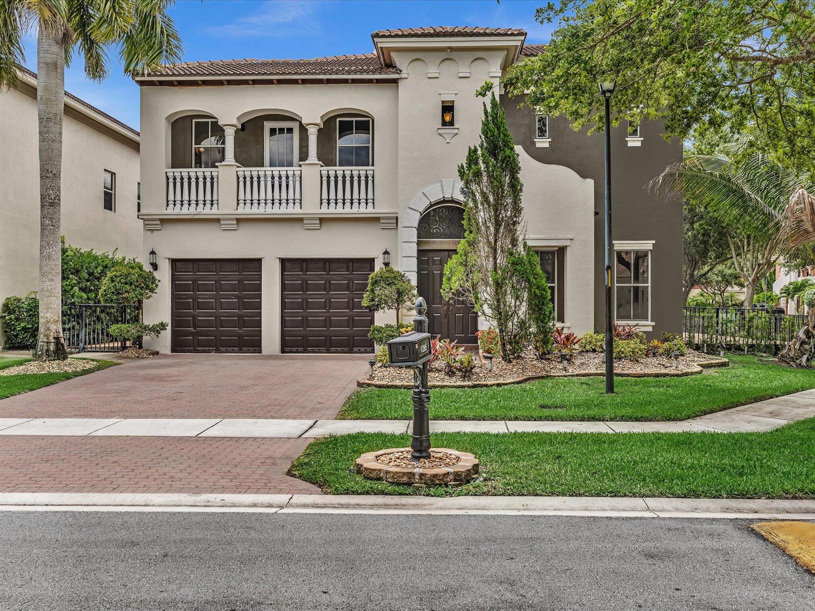 A two-story Mediterranean-style house with a two-car garage, balcony, and a paved driveway — 9286 Nugent Trail, West Palm Beach FL 33411, WEST PALM BEACH, FL