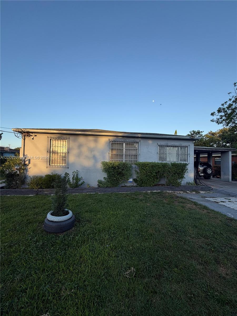 A single-story house with a gray exterior, security bars on windows, and a carport — 6741 NW 6th Ct, Miami FL 33150, MIAMI, FL
