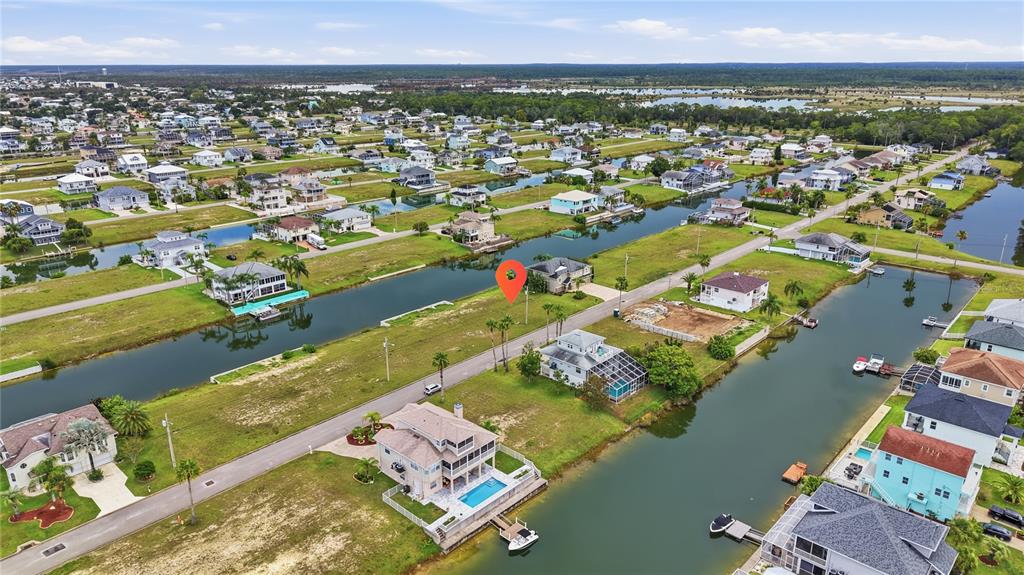 An aerial view shows a vacant waterfront lot marked with a pin in a residential neighborhood — 3431 JEWFISH DRIVE, HERNANDO BEACH, FL
