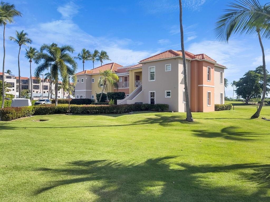 A multi-story apartment building with a red tile roof sits behind a large grassy lawn — 170 Candelero Dr. PALMAS DEL MAR, LAS PALMAS DORADAS UNIT 501, HUMACAO, PR