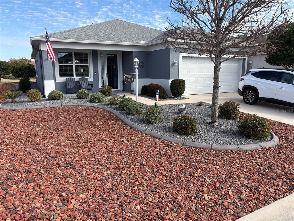 A single-story house with a gray exterior, a two-car garage, and a rock-covered front yard — 7819 SW 88TH STREET ROAD, OCALA, FL