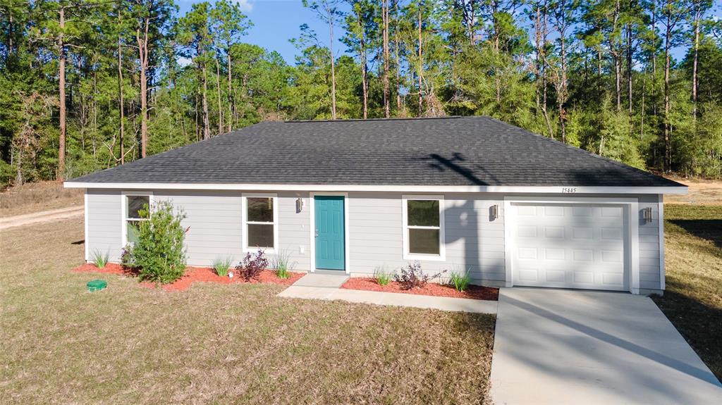 A single-story gray house with a teal front door and a one-car garage — 1451 SW 153RD COURT, OCALA, FL