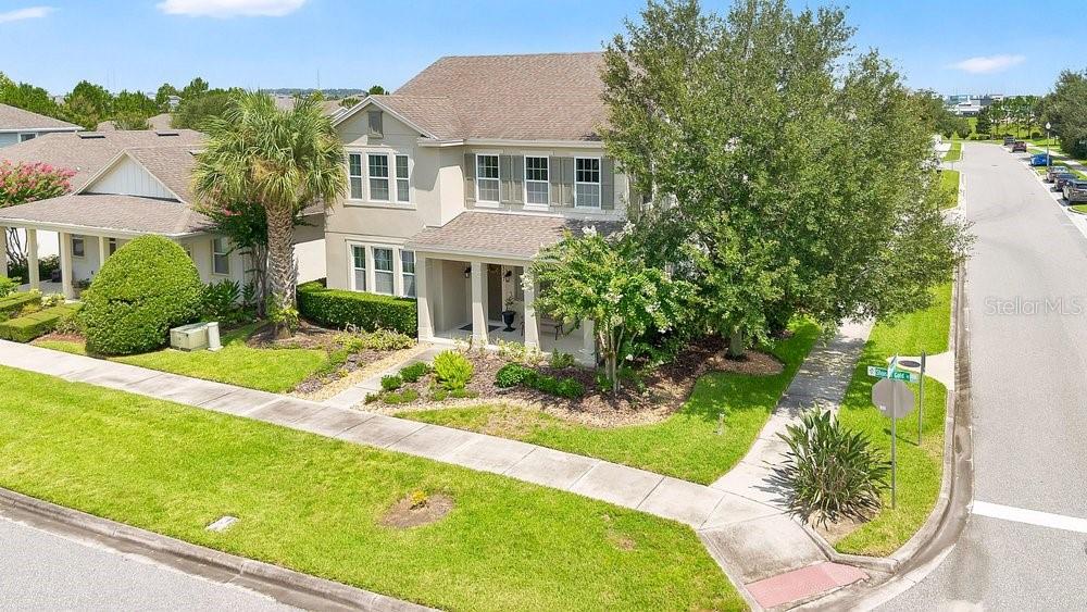 A two-story suburban house with a covered front porch, tan siding, and a landscaped yard — 15367 SHONAN GOLD DRIVE, WINTER GARDEN, FL