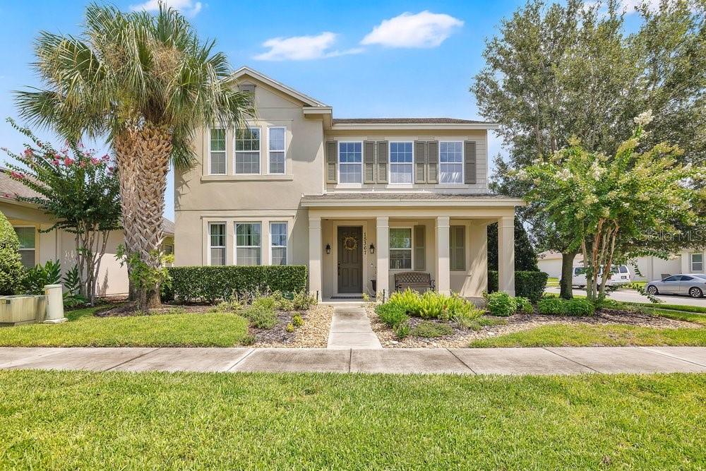 A two-story suburban house with a covered front porch, palm tree, and landscaped yard — 15367 SHONAN GOLD DRIVE, WINTER GARDEN, FL