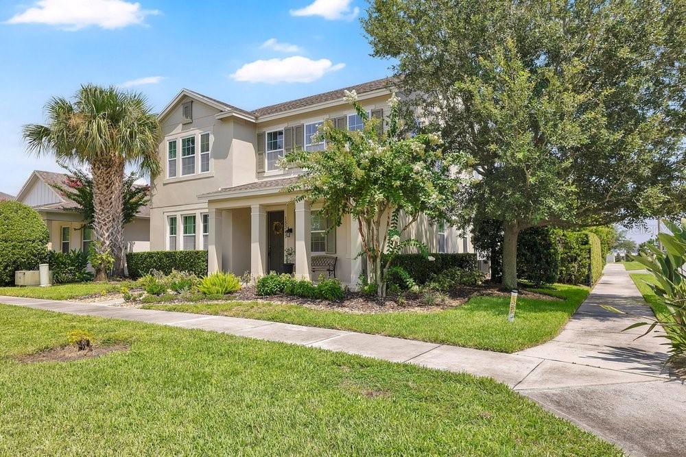 A two-story house with a palm tree, a front porch, and a sidewalk in front — 15367 SHONAN GOLD DRIVE, WINTER GARDEN, FL