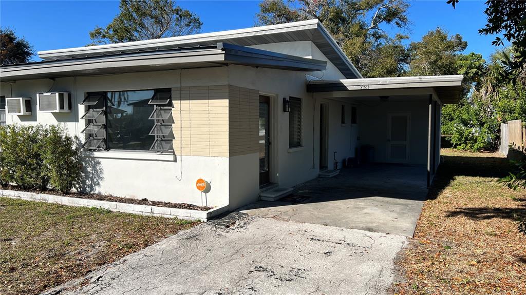 A single-story house with a flat roof, a carport, and a concrete driveway — 2323 BELMAR DRIVE, BELLEAIR BLUFFS, FL