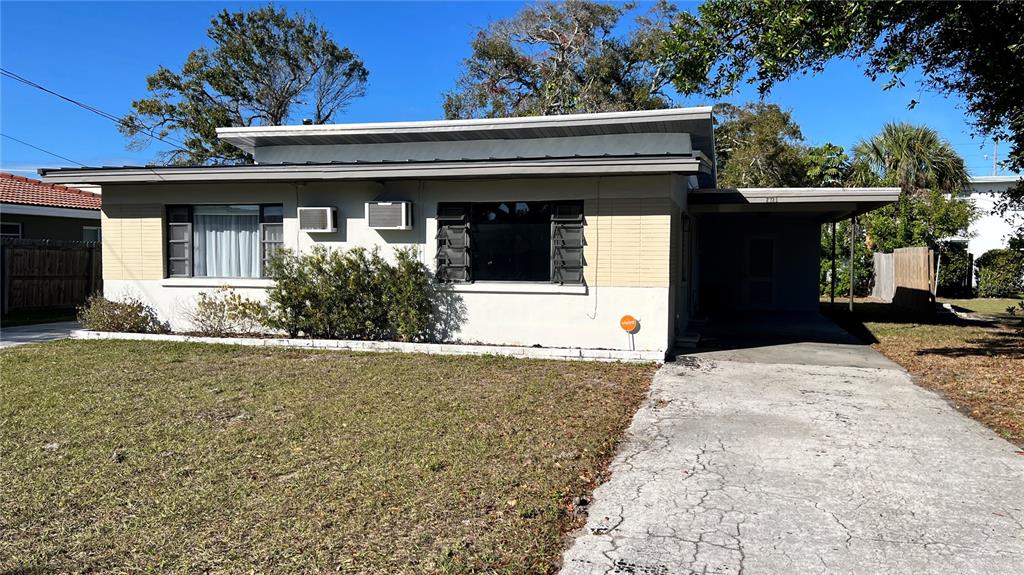 A single-story house with a flat roof, tan siding, and a concrete driveway — 2323 BELMAR DRIVE, BELLEAIR BLUFFS, FL