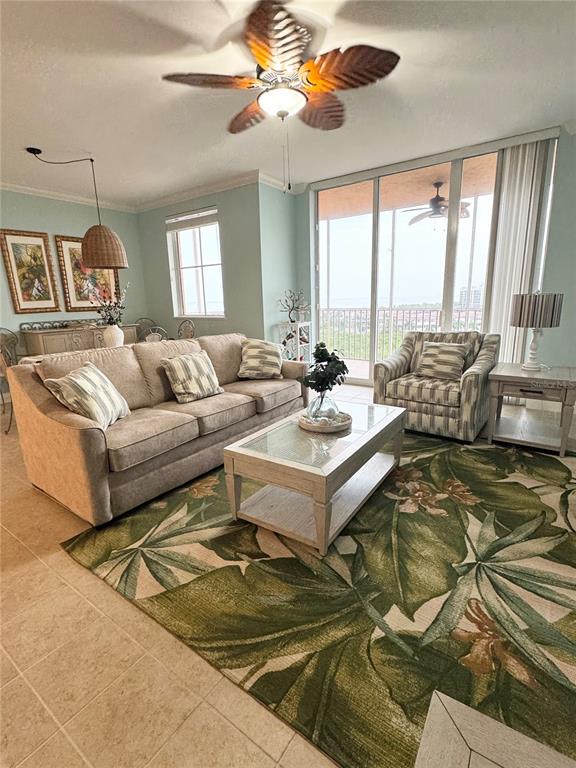 A living room features a beige sofa, patterned armchair, coffee table, and a large tropical rug — 3191 MATECUMBE KEY ROAD UNIT 607, PUNTA GORDA, FL