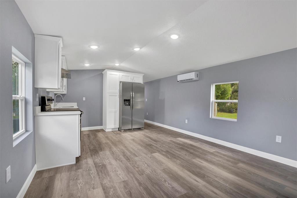 A kitchen with white cabinets, stainless steel appliances, gray walls, and wood-look flooring — 2667 SNAPPING TURTLE DRIVE, LAKE WALES, FL
