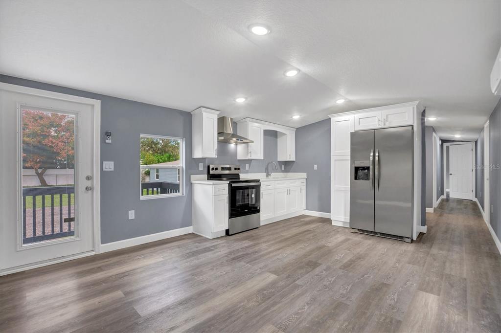 A kitchen with white cabinets, stainless steel appliances, and gray walls over wood-look flooring — 2667 SNAPPING TURTLE DRIVE, LAKE WALES, FL