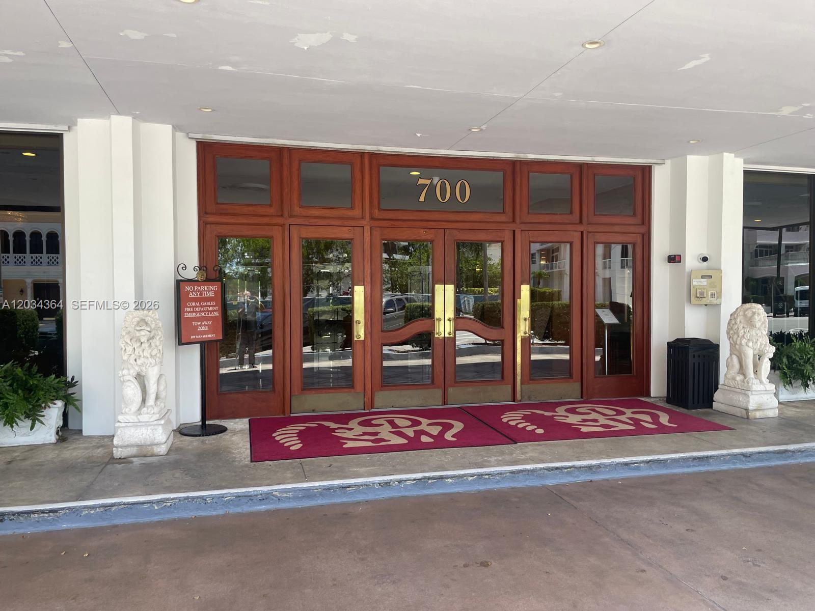 The exterior of a multi-story building with a parking lot and cars in front — 700 Biltmore Way # 1015, Coral Gables FL 33134, CORAL GABLES, FL