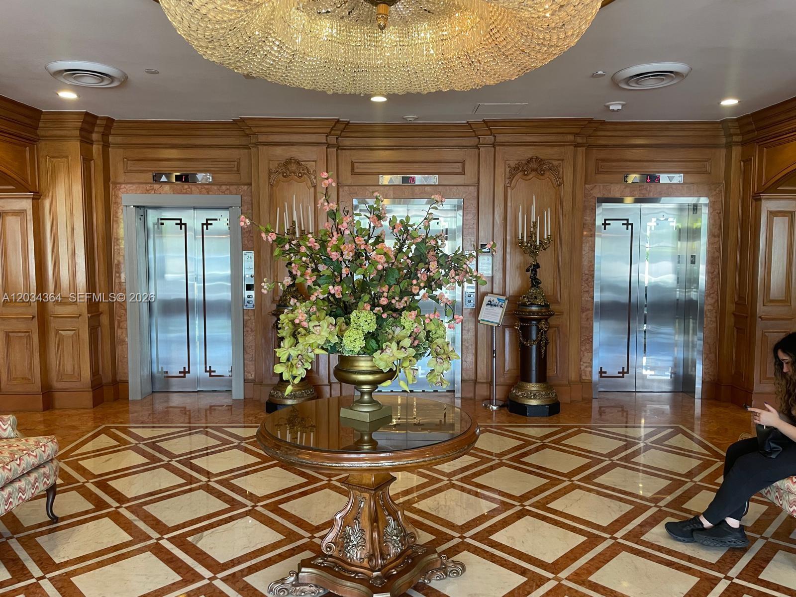 The exterior entrance features double wooden doors with glass panels, stone lion statues, and rugs — 700 Biltmore Way # 1015, Coral Gables FL 33134, CORAL GABLES, FL