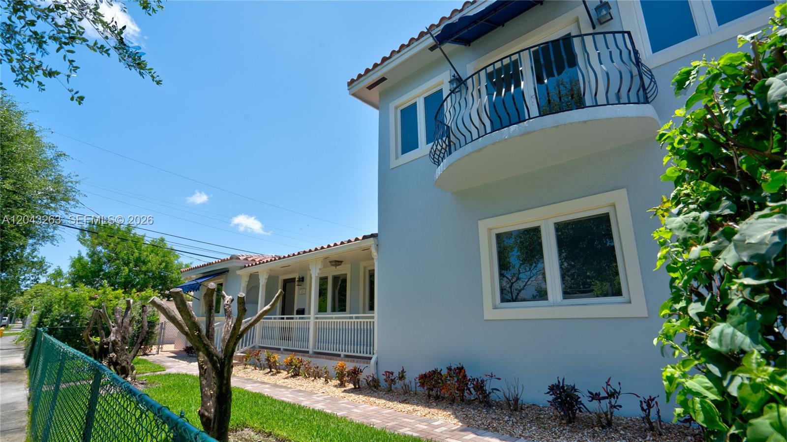 A two-story light blue house features a second-floor balcony and a covered front porch — 500 SW 51st Ct # 1, Miami FL 33134, MIAMI, FL