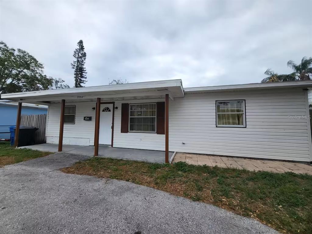A single-story house with white horizontal siding and a covered front porch — 3552 38TH AVENUE N, ST PETERSBURG, FL