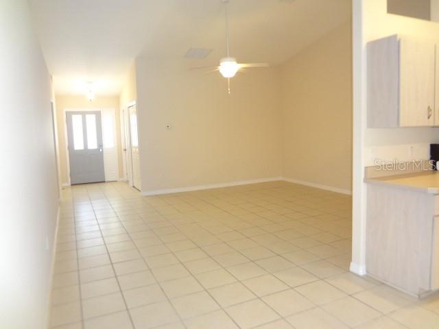 A tiled living area features a ceiling fan and an adjacent kitchen with light cabinets — 11 PONTIAC LANE UNIT B, PALM COAST, FL