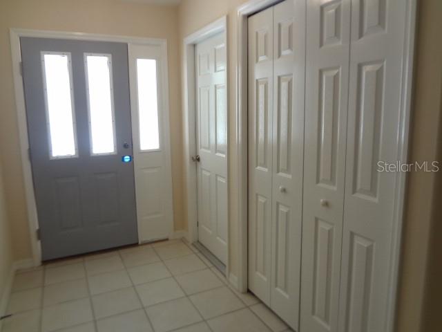 An entryway features a gray front door, a white closet, and light-colored floor tiles — 11 PONTIAC LANE UNIT B, PALM COAST, FL