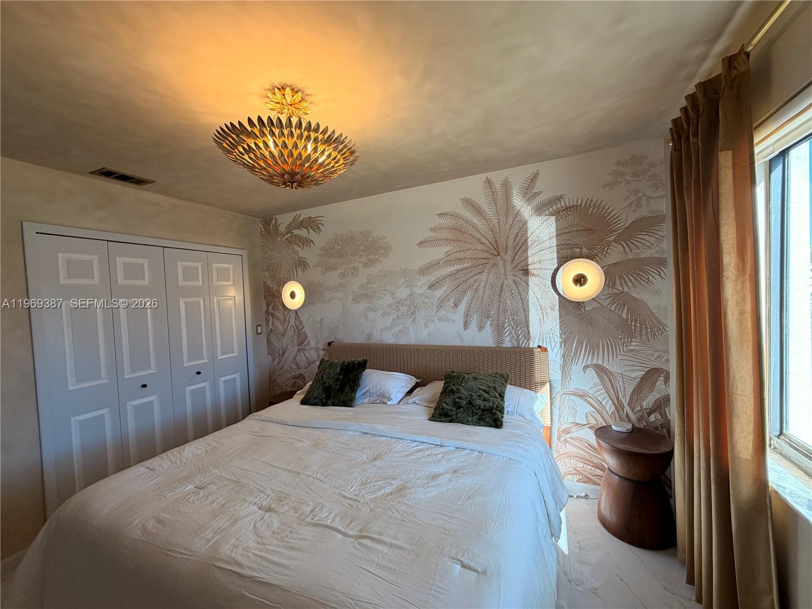 A bedroom features a palm-themed mural, a rattan headboard, and a gold-toned ceiling fixture — 14617 SW 167th Ter, Miami FL 33177, MIAMI, FL