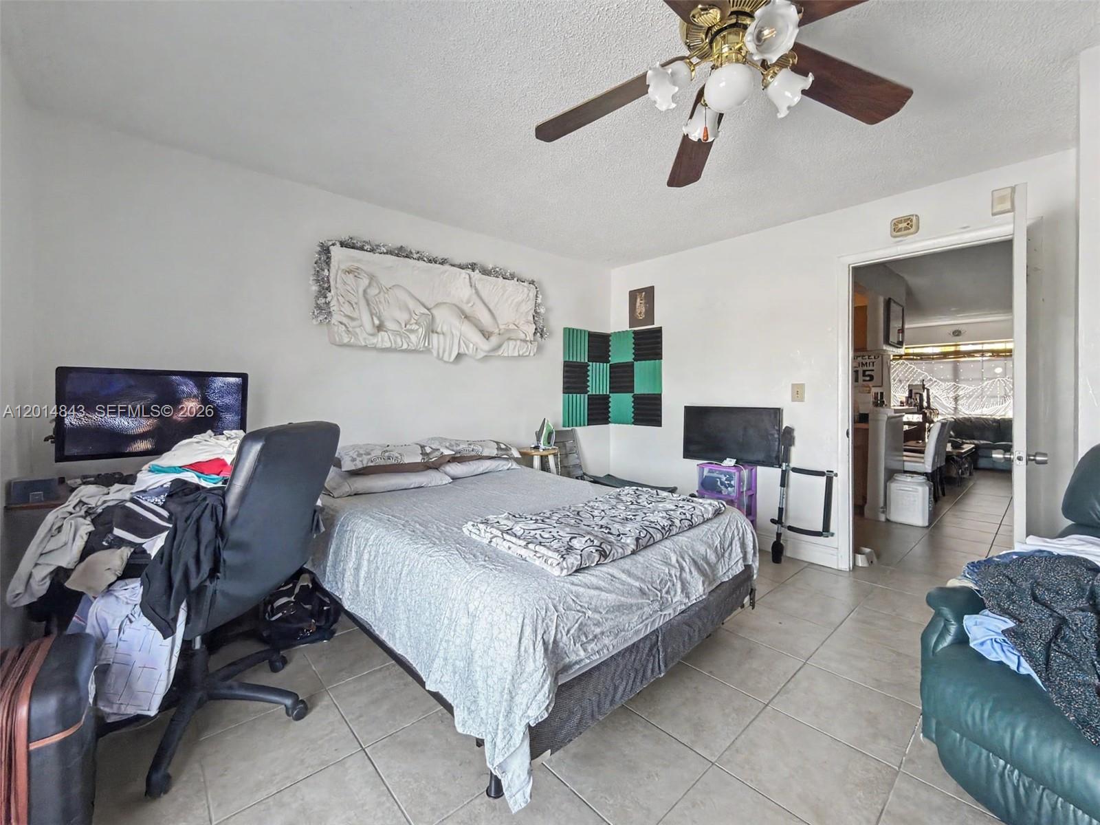 A bedroom features a bed, a desk with a computer, and a ceiling fan — 7155 Miami Lakes Dr # P16, Miami Lakes FL 33014, MIAMI LAKES, FL
