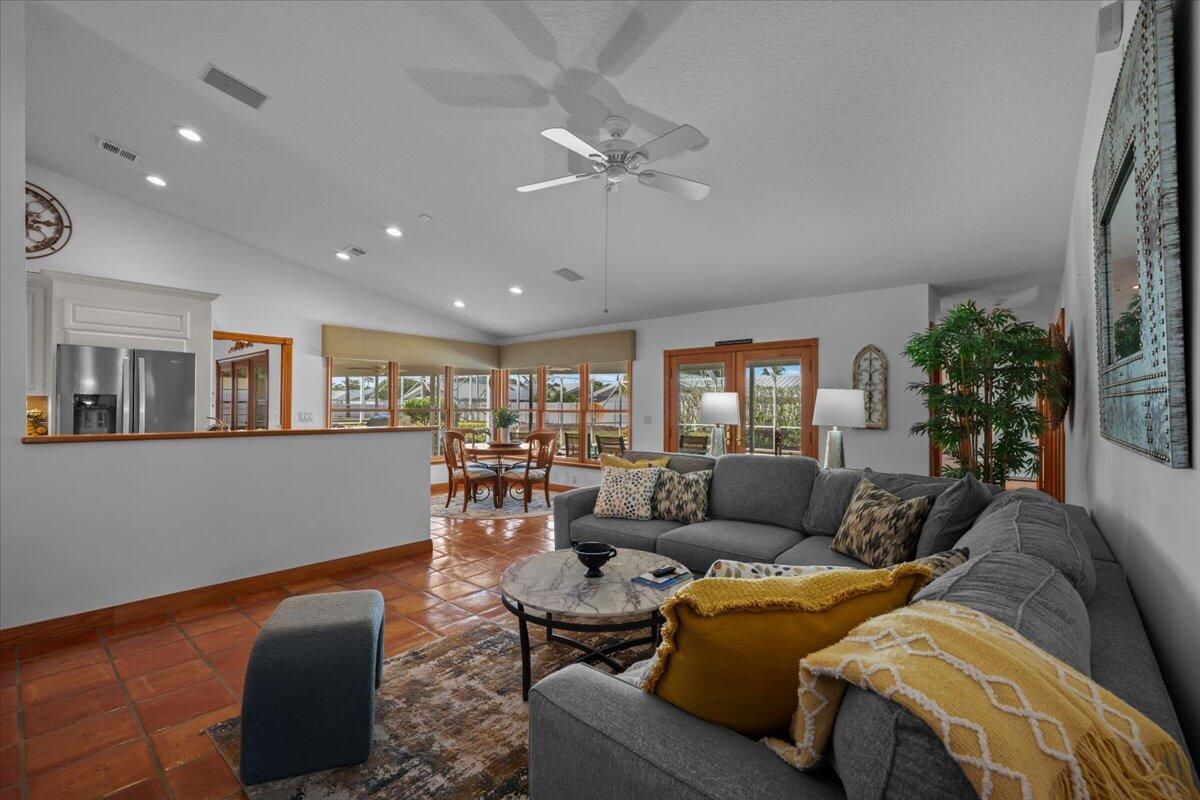 A living room with gray sectional seating, a marble coffee table, and terracotta tile floors — 103 Olympus Circle, Jupiter FL 33477, JUPITER, FL