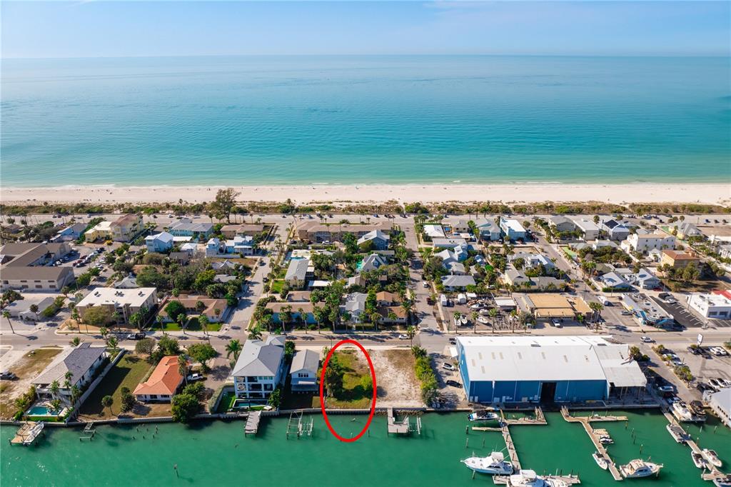 An aerial view shows a vacant waterfront lot circled in red near a beach — 1805 PASS-A-GRILLE WAY, ST PETE BEACH, FL