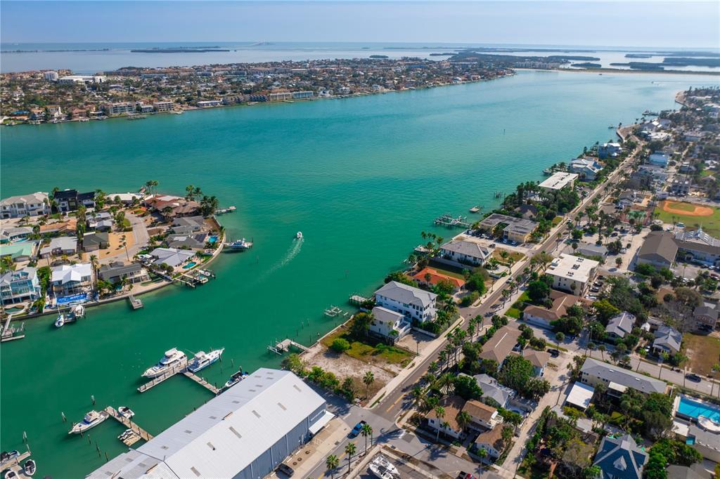 An aerial view shows a coastal neighborhood with houses, a marina, and a boat channel — 1805 PASS-A-GRILLE WAY, ST PETE BEACH, FL