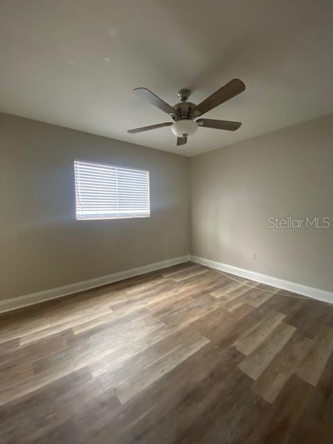 An empty bedroom features light-colored walls, a ceiling fan, and wood-look flooring — 3914 NEPTUNE STREET UNIT 1, TAMPA, FL
