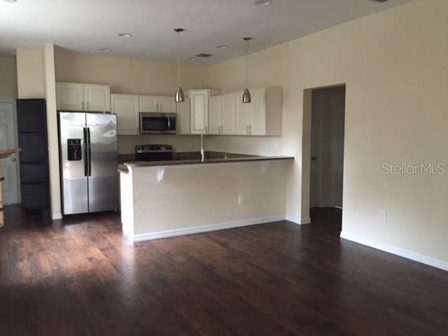A kitchen with white cabinets, stainless steel appliances, and dark wood flooring — 2608 E JEFFERSON STREET, ORLANDO, FL