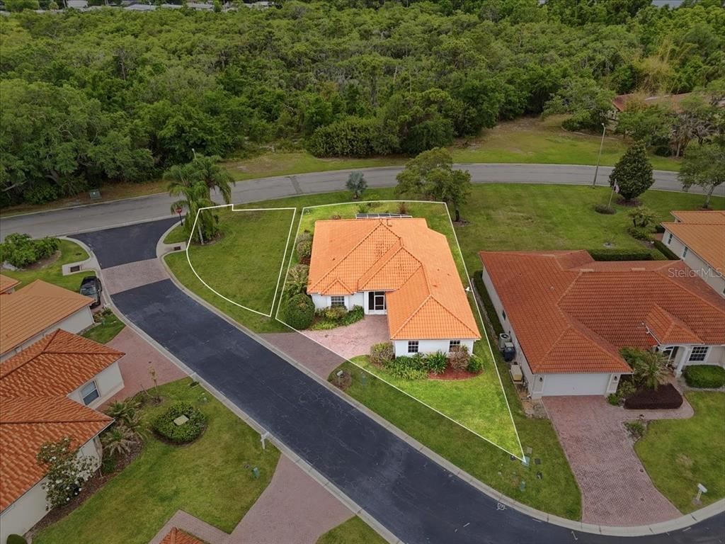 An aerial view shows a house with an orange tile roof on a corner lot — 3027 RICHMOND DRIVE, WINTER HAVEN, FL