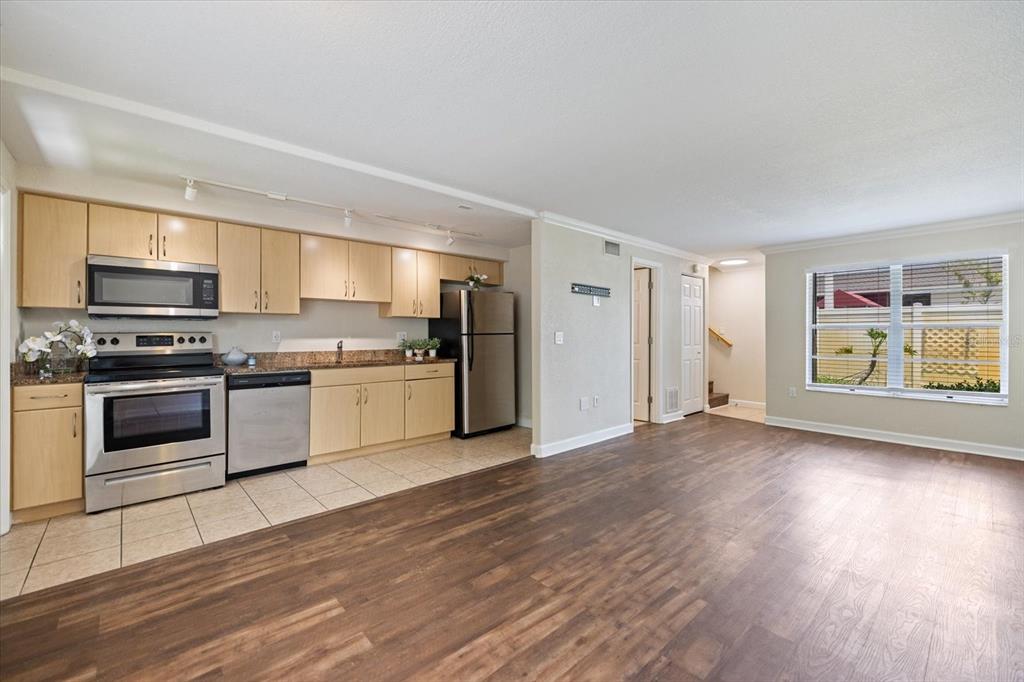 A kitchen with light wood cabinets and stainless steel appliances opens to a living area — 960 HIGHLAND STREET UNIT A7, SARASOTA, FL