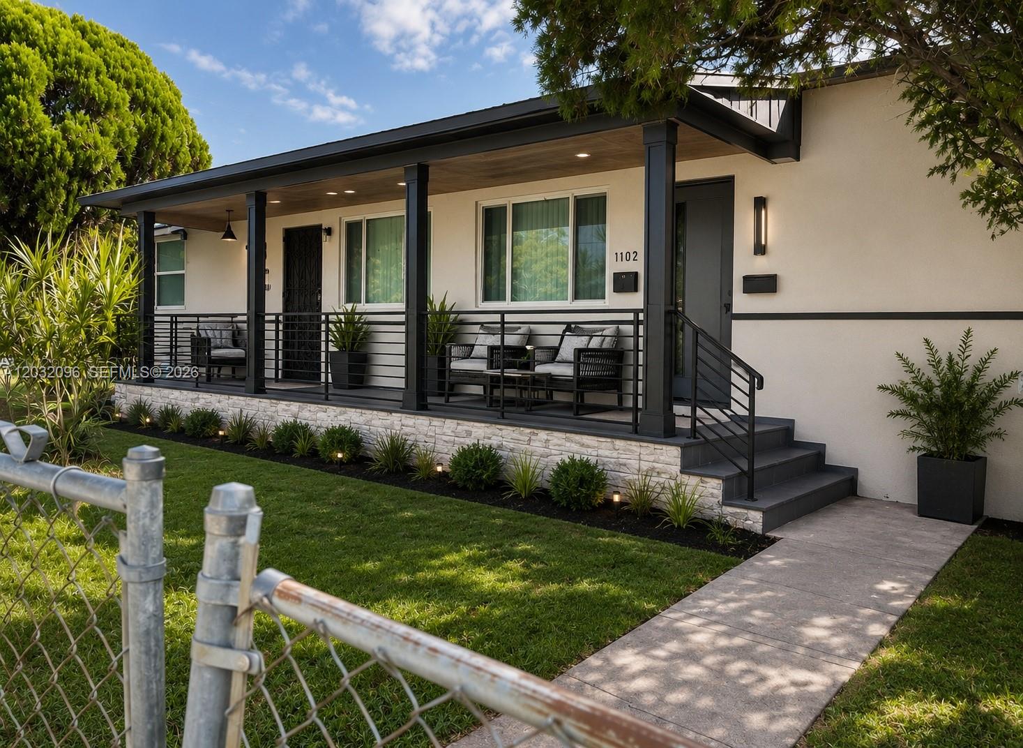 A single-story house with a covered porch, stone base, and black metal railings — 1100 NW 57th St, Miami FL 33127, MIAMI, FL