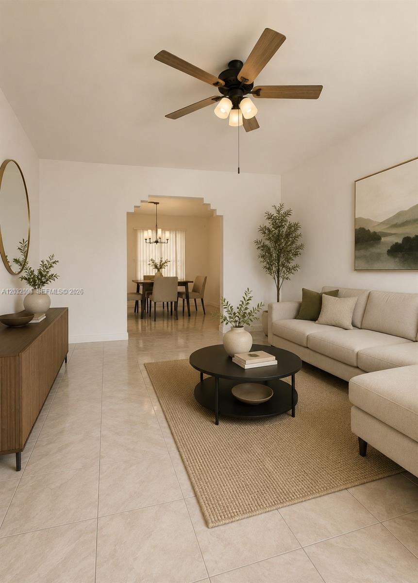 A living room features a beige sofa, a round coffee table, and a ceiling fan — 1100 NW 57th St, Miami FL 33127, MIAMI, FL
