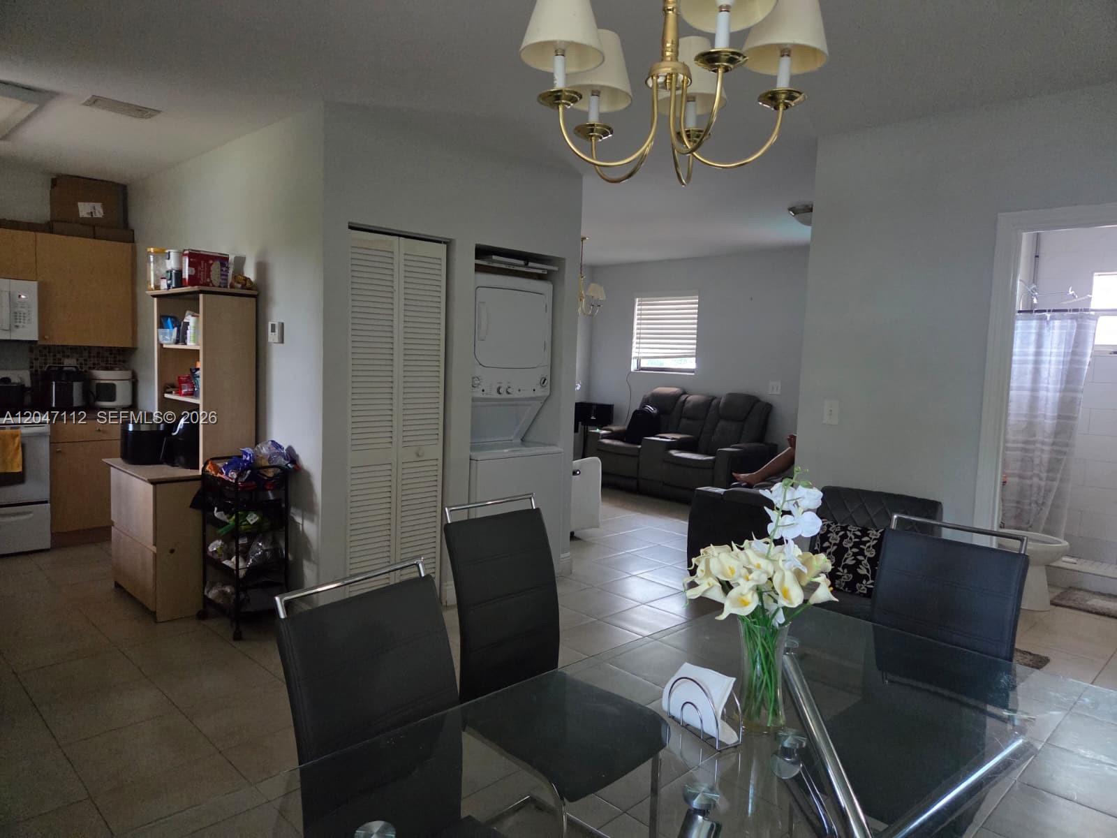 A dining area with a glass table overlooks a living room and a kitchen — 2816 NW 15th St # 2R, Miami FL 33125, MIAMI, FL