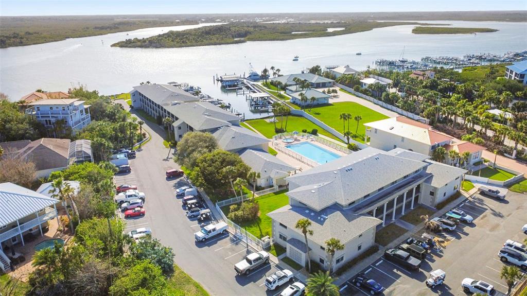 An aerial view shows a waterfront resort complex with a swimming pool and parking lots — 2100 N PENINSULA AVENUE UNIT 1130, NEW SMYRNA BEACH, FL