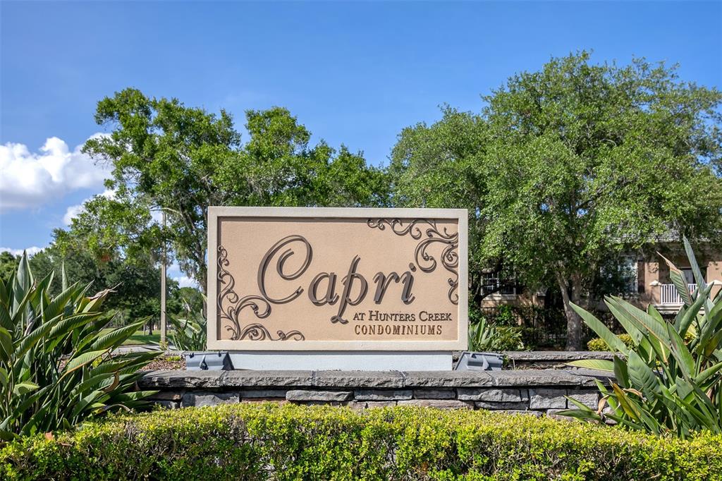 A stone-based monument sign displays the name Capri at Hunters Creek Condominiums outdoors — 14316 FREDRICKSBURG DRIVE UNIT 518, ORLANDO, FL