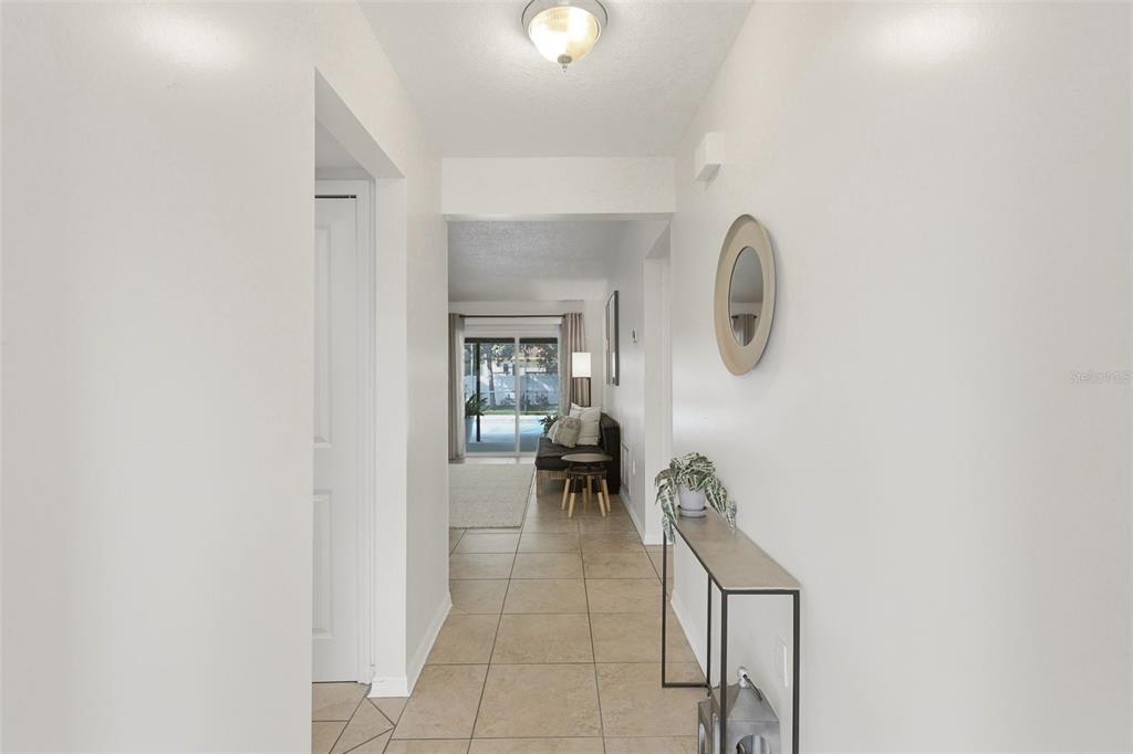 A tiled hallway leads to a living area with a sliding glass door to a patio — 8614 SANDBERRY BLVD, ORLANDO, FL