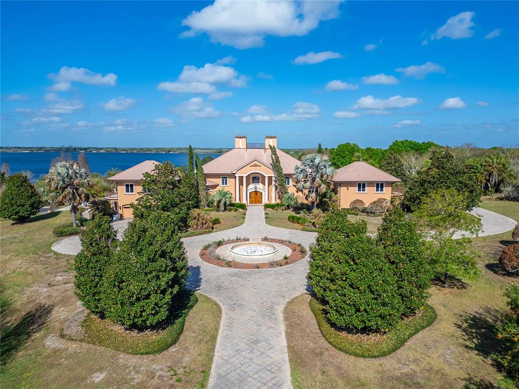 An aerial view of a large tan mansion with a circular driveway and a fountain — 501 ADAMS BARN ROAD, AUBURNDALE, FL