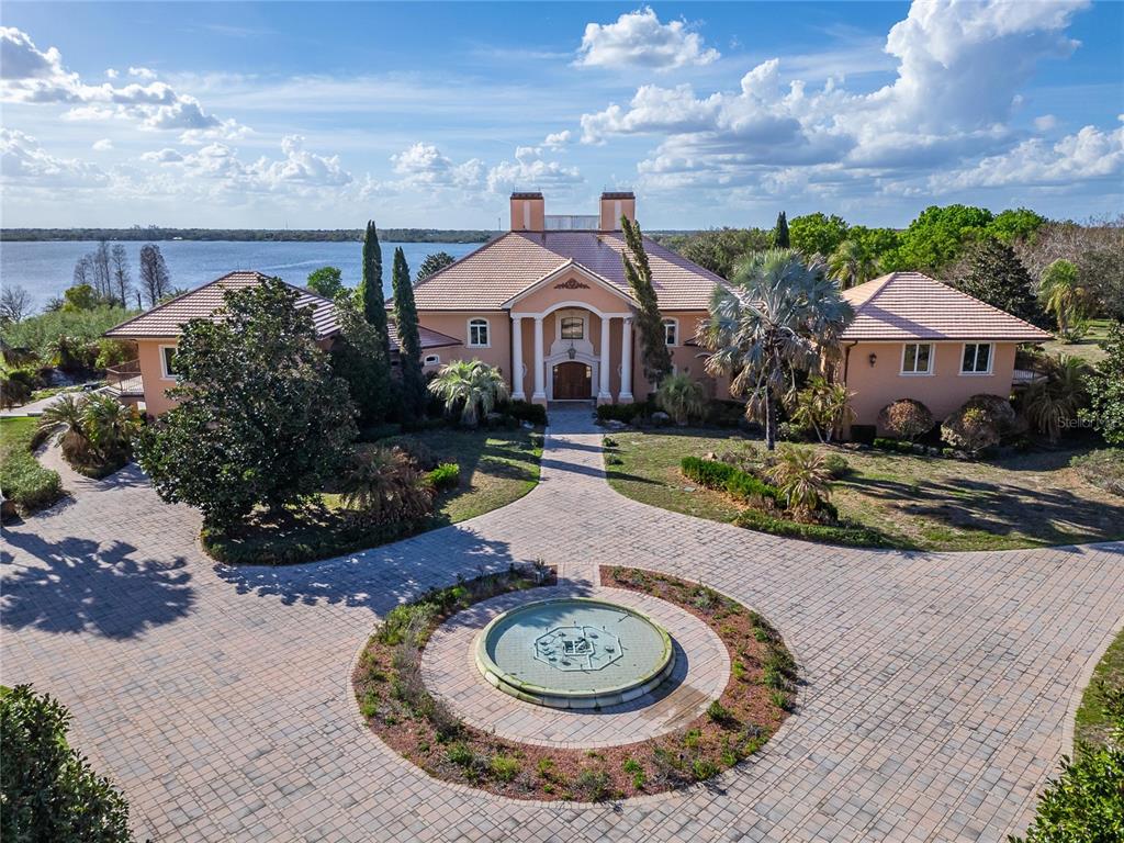 An aerial view shows a large peach-colored house with a circular fountain in the driveway — 501 ADAMS BARN ROAD, AUBURNDALE, FL