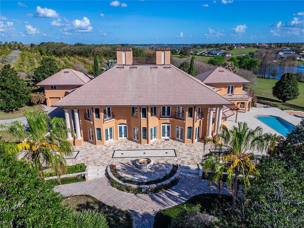 An aerial view of a large, multi-story peach-colored mansion with a pool and patio — 501 ADAMS BARN ROAD, AUBURNDALE, FL