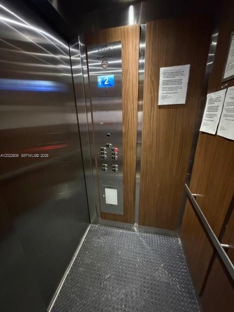 The interior of an elevator features stainless steel walls, wood paneling, and a button panel — 319 NE 14th Ave # 607, Hallandale Beach FL 33009, HALLANDALE BEACH, FL