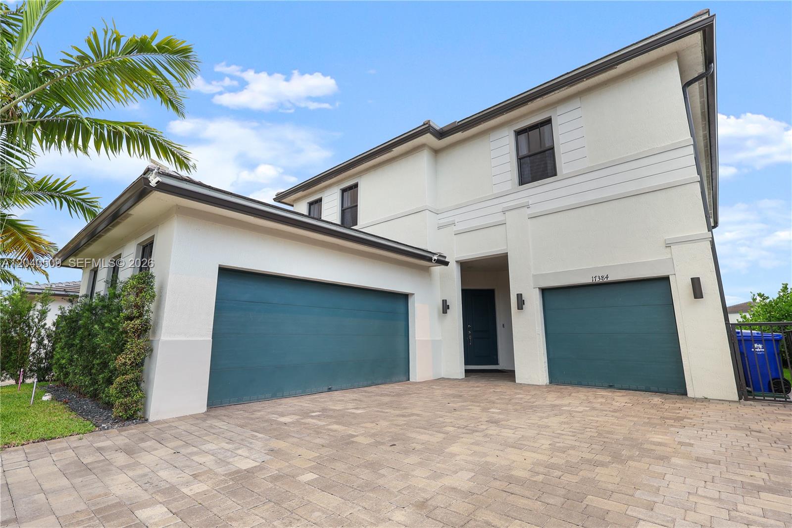 A two-story house features a paved driveway, two teal garage doors, and a palm tree — 17384 SW 41st St, Miramar FL 33029, MIRAMAR, FL