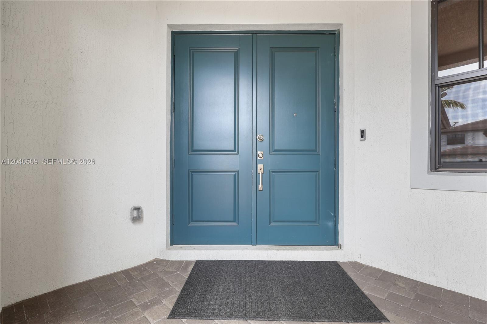 A teal double front door with a dark gray mat on a paved porch — 17384 SW 41st St, Miramar FL 33029, MIRAMAR, FL