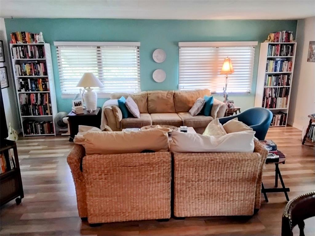 A living room features two wicker chairs, a tan sofa, and two white bookshelves — 10118 N LAKE DRIVE UNIT 30, LARGO, FL