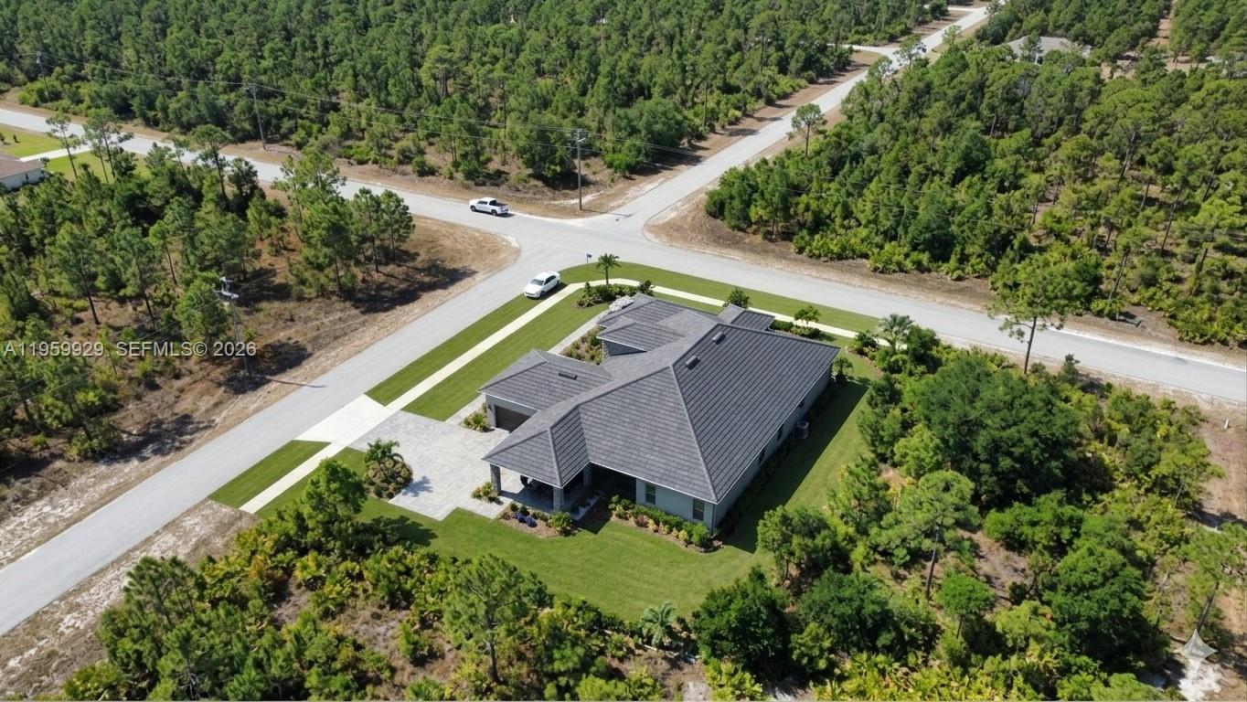 An aerial view shows a single-story house with a dark roof on a corner lot — 3007 E 10 St, Lehigh Acres FL 33972, LEHIGH ACRES, FL