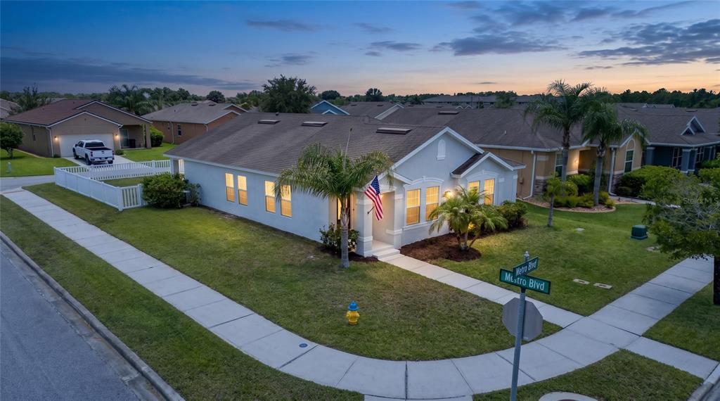 An aerial view of a single-story suburban house with a corner lot and American flag — 3320 MARSILI AVENUE, NEW SMYRNA BEACH, FL