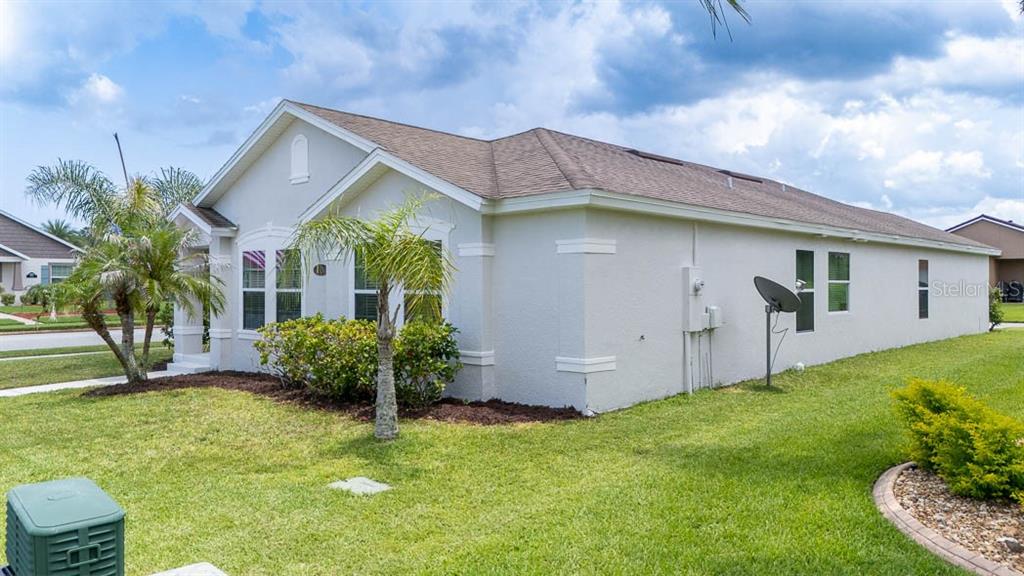 A side view of a light-colored single-story house with a lawn and palm trees — 3320 MARSILI AVENUE, NEW SMYRNA BEACH, FL