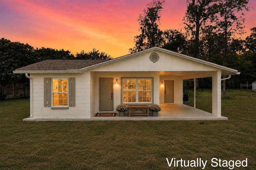 A single-story house with a covered porch and white siding sits on a grassy lawn — 641 NW 258TH STREET, NEWBERRY, FL