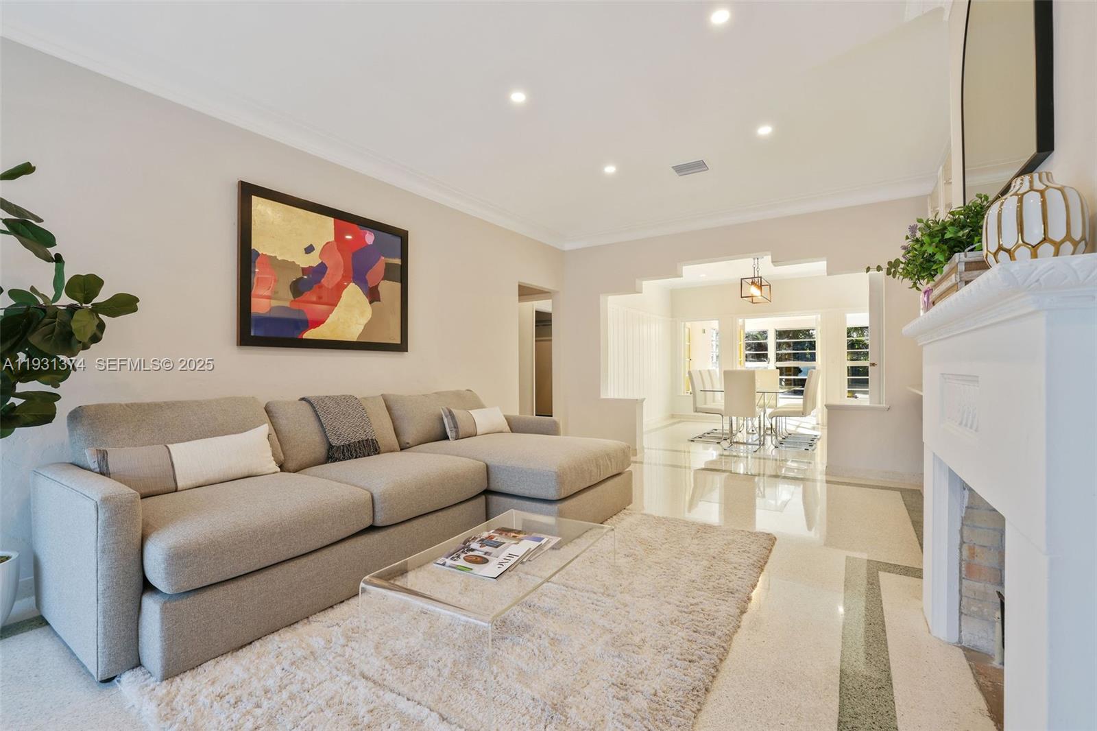 A living room features a grey sectional sofa, a glass coffee table, and a fireplace — 3760 Royal Palm Ave, Miami Beach FL 33140, MIAMI BEACH, FL