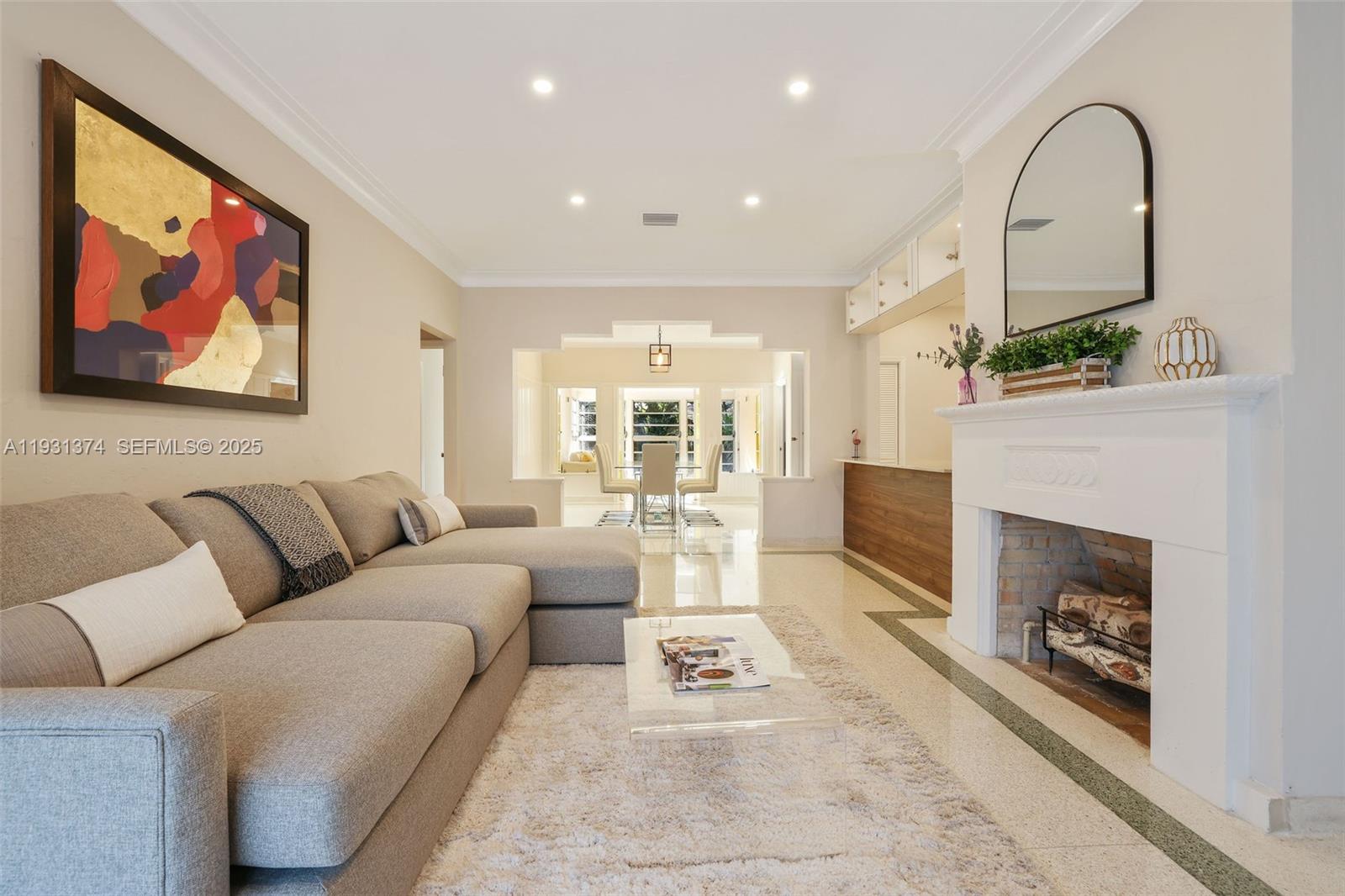 A living room features a grey sectional sofa, a fireplace, and a dining area beyond — 3760 Royal Palm Ave, Miami Beach FL 33140, MIAMI BEACH, FL