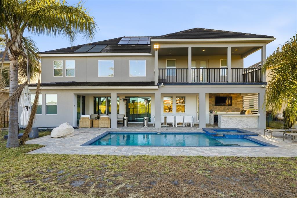 The rear exterior of a two-story house features a swimming pool, patio, and outdoor kitchen — 11545 BRICKYARD POND LANE, WINDERMERE, FL